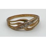 A 9ct gold diamond set crossover design band style ring. Open work crossover central design set with
