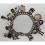 A silver double link charm bracelet with spring ring clasp and 17 silver & white metal charms. Clasp