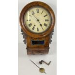A walnut veneer wooden cased antique wall handing clock with striking bell to top. Carved floral