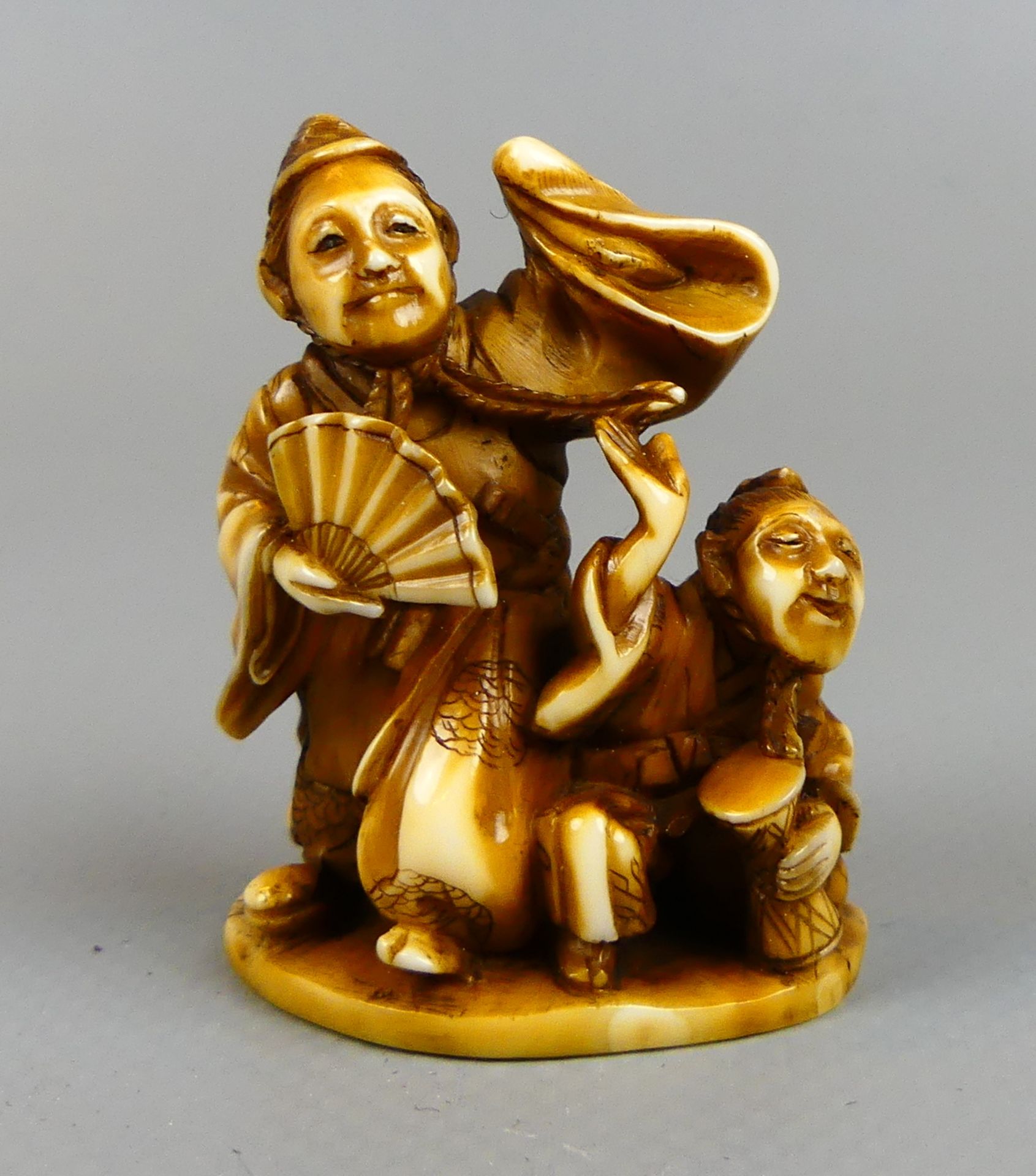 Netsuke, 2 Personen, ein Trommler, ein Tänzer, unten signiert, braune Pattina,