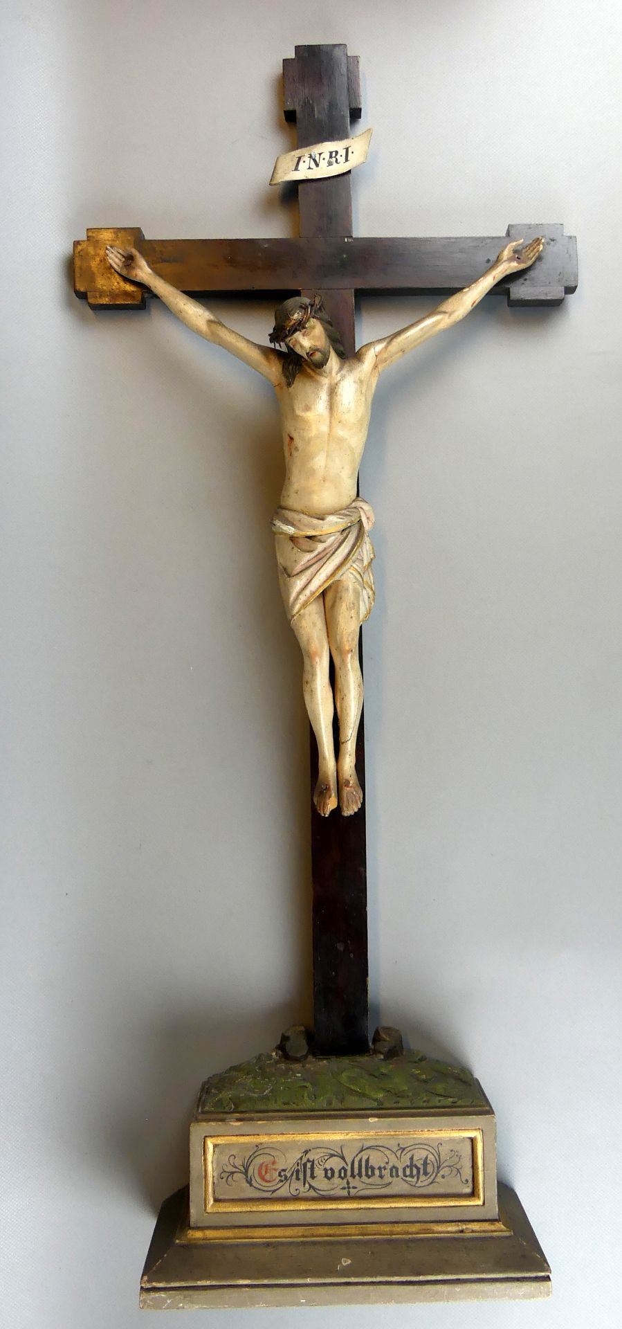 "Jesus am Kreuz", Holzskulptur, auf Sockel, mit Inschrift "Es ist vollbracht",