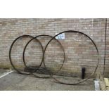 Three large cast iron wheel trims, approx. 141cm diameter and 159cm diameter (3)