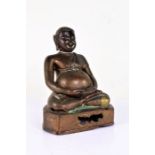 Oriental bronze Buddha, with short hair above long ear lobes and a large stomach on a plinth base,