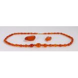 Amber necklace, with a graduated row of beads interspersed with small beads, the largest bead 17mm