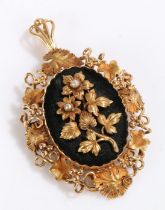Yellow metal brooch, with a black ground with flowers and vines and a decorated border of flowers