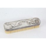 Chinese white metal handled dressing table brush, with embossed depiction of a dragon and