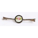 Silver and enamel bar brooch with a central circle depicting a rose on a white background with a