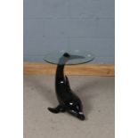 Dolphin occasional table, the circular clear glass topped raised on a dolphin's tail, 46cm diameter