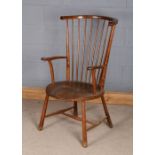 Comb back elbow chair, the substantial cresting rail above turned spindles, solid circular dished