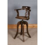 Arts and Crafts style swivel high stool, with pierced heart splat, cane seat and raised on four