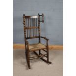 Edwardian rocking chair, with bobbin turned spindle back and arms, rush seat, on bobbin turned legs