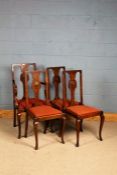 Set of four oak dining chairs, the splats decorated with a carved shell, raised on cabriole legs,