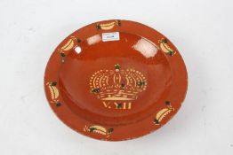 English slipware pottery dish, the red ground decorated with a crown above V. Y. II, with six