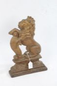 Gilded cast iron doorstop, in the form of a seated lion, 37.5cm tall