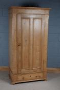 Stripped pine single door wardrobe, the door enclosing a hanging rail to the interior, fitted single