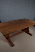 Large pitch pine kitchen table, the oblong top raised on shaped supports and sledge feet (one