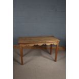 Pine dining table, the rectangular top with rounded corners above a shaped frieze and square legs,