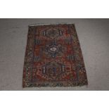 Middle Eastern carpet, the red ground with triple lozenge pattern central field and multiple