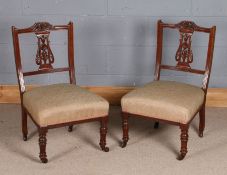 Pair of late Victorian nursing chairs, having fret carved back slats, floral stuff over seats and