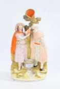 Victorian Staffordshire figure group, in the form of a couple drinking from a vessel, 32cm tall