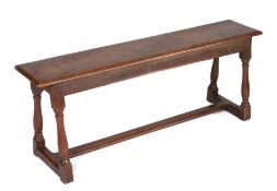 17th Century elm long bench, the rectangular top above turned legs united by H form stretchers,