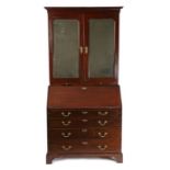 George III mahogany bureau bookcase, the concave pediment above a pair of mirrored doors enclosing