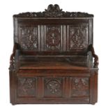 17th Century style oak bench, the carved and arched pediment above three carved panels, and a hinged