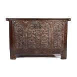 Mid 17th Century oak coffer, the rectangular top enclosing a candle slot and deep storage