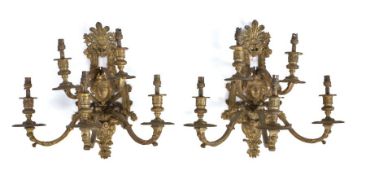Pair of gilt metal wall lights, the five branches projecting from the leaf and the masks of