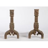 Pair of iron fire dogs, in the Gothic taste, a shield to the centre above arched legs, 44cm high, (