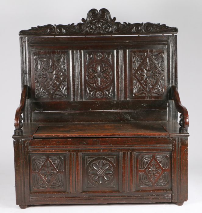 17th Century style oak bench, the carved and arched pediment above three carved panels, and a hinged - Image 2 of 2