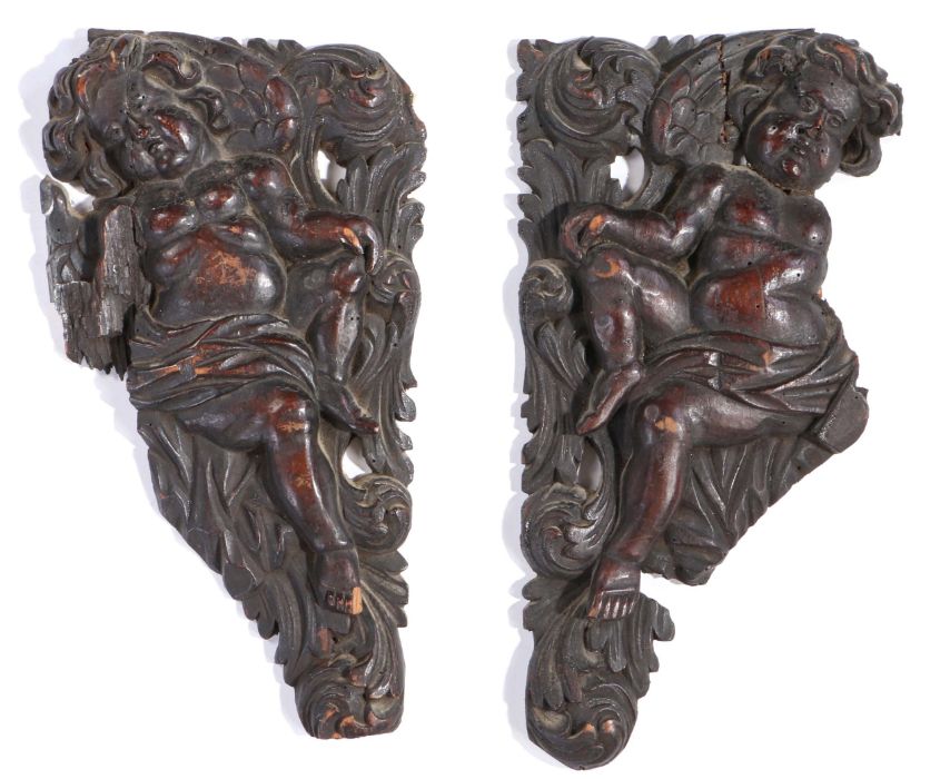 Pair of 17th Century walnut appliques, designed as spandrels, carved as cherubs among scrolling