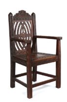 19th Century walnut armchair, Welsh, profusely chip carved with an arching top rail above a heart to