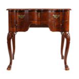 19th Century Dutch mahogany lowboy, the shaped top above a long drawer and two short drawers above