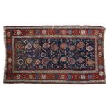 Caucasian Dozar rug, with multi-coloured motifs on a blue ground, within a red border, 214cm long