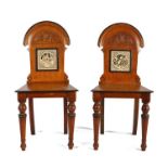 Pair of Victorian oak hall chairs, the arched backs above a tile to each by John Moyr Smith from the