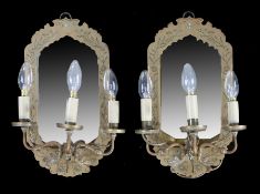 Pair of brass wall sconces, the mirror back panels with foliate engraved frames and a three branch