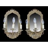 Pair of brass wall sconces, the mirror back panels with foliate engraved frames and a three branch