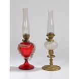 Hinks oil lamp, the clear glass chimney above a ruby glass reservoir with overlaid white glass