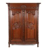 19th Century French oak armoire, the concave cornice above a grape carved frieze and a pair of