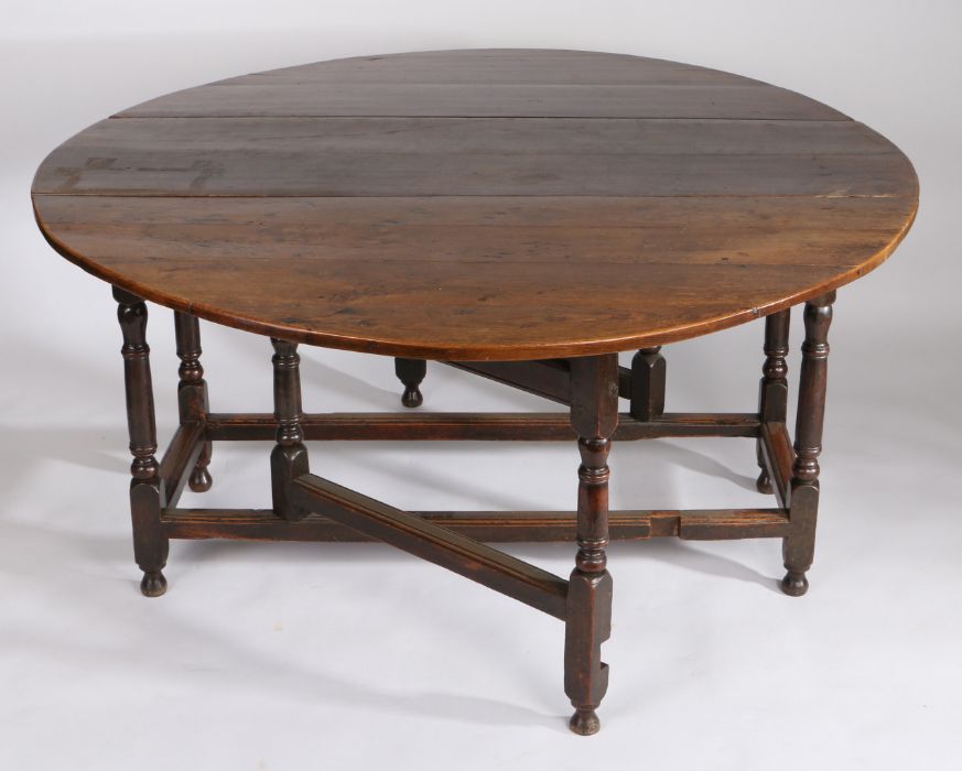 A large 18th Century oak gateleg table, the oval drop leaf table above a shallow frieze, one end - Image 3 of 5