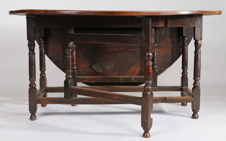 A large 18th Century oak gateleg table, the oval drop leaf table above a shallow frieze, one end - Image 5 of 5