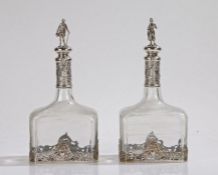 Pair of 19th Century Continental silver mounted bottles/decanters, the figural finials in the form