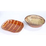 Two 19th Century slipware baking dishes, the first in a brick red glaze and yellow wriggles, 32cm