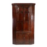 George III oak standing corner cupboard, the concave dentil moulded cornice above a pair of