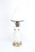 Continental porcelain oil lamp, the clear glass chimney and frosted white shade above an owl form