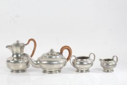 Lion pewter four piece tea set, with beaten decoration, consisting of teapot, hot water jug, milk