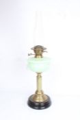 Best British Make oil lamp with clear glass chimney above a frosted green glass reservoir, raised on