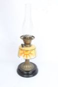 British Made oil lamp, the clear glass chimney above a sunburst decorated reservoir, reeded brass
