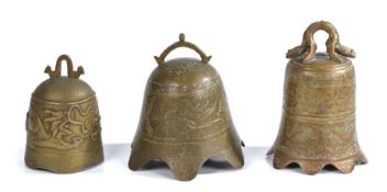 Three Chinese brass bells, to include an example with a stylised dragon, another with a flared